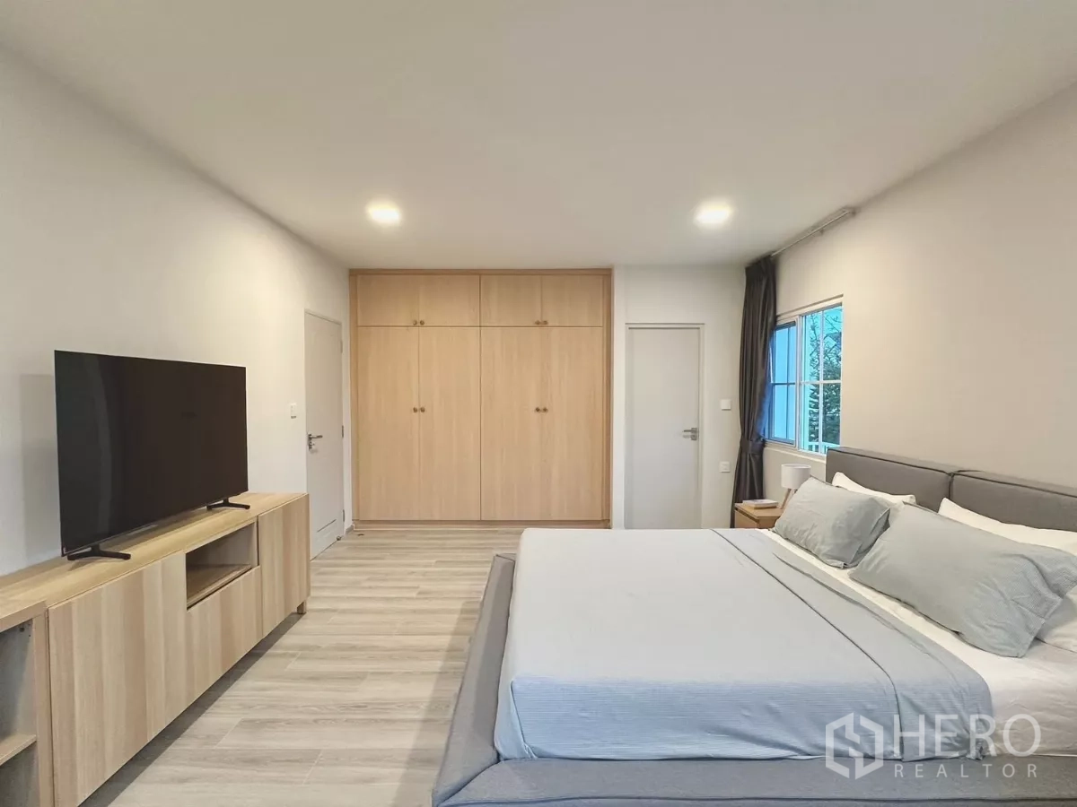 独立式住宅 出租在Bang Phli, Samut Prakan - 主卧电视墙，配大屏电视与窗边书桌。