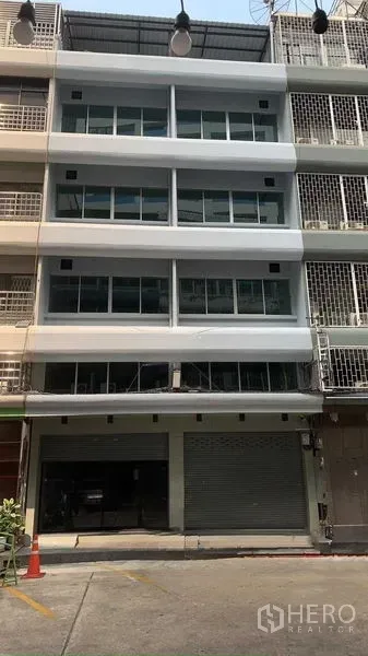 Office Space for rent in Bang Rak, Bangkok - Front exterior of a multi-storey office shophouse with wide glass windows and a ground-floor roller shutter in Bang Rak.