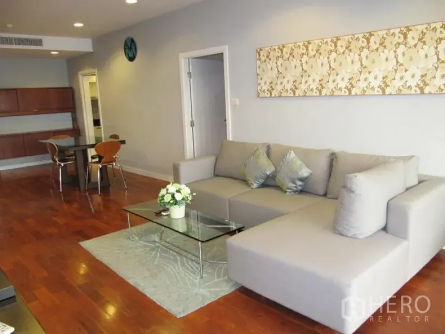 คอนโด ให้เช่าในKhlong Toei, Bangkok - พื้นที่นั่งเล่นและรับประทานอาหารแบบเปิดโล่ง โซฟาตัวแอลสีเทา โต๊ะกระจก และพื้นไม้