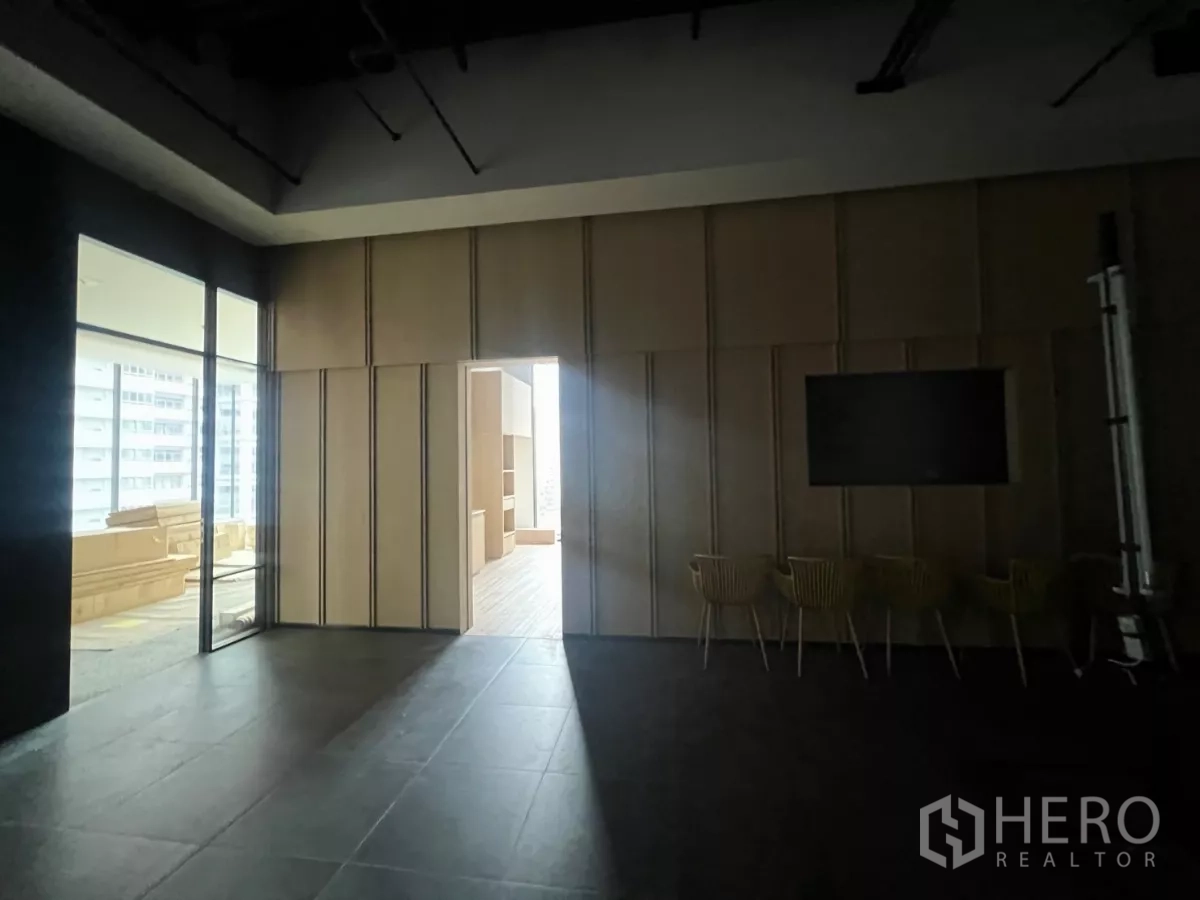 零售空间 出租 - 多功能休息区，木质墙面与玻璃隔断，连接更明亮的展厅。