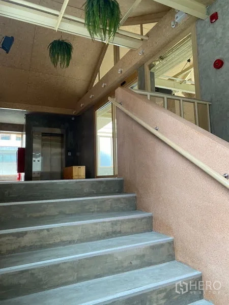 พื้นที่ขายปลีก ให้เช่าในWatthana, Bangkok - โถงบันไดภายในขั้นคอนกรีต มีราวจับและลิฟต์ในโทนมินิมอล