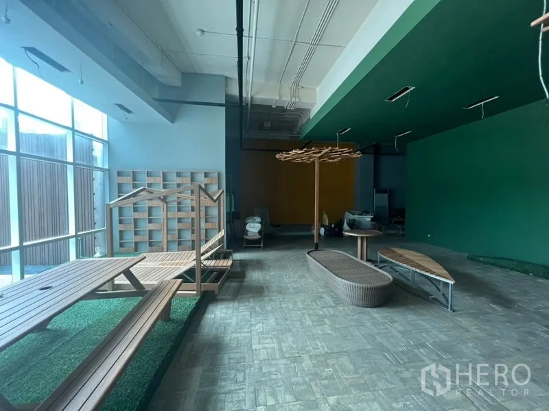 零售空间 出租在Khlong Toei, Bangkok - 前场靠玻璃立面，长接待台、座位区与充足自然光。