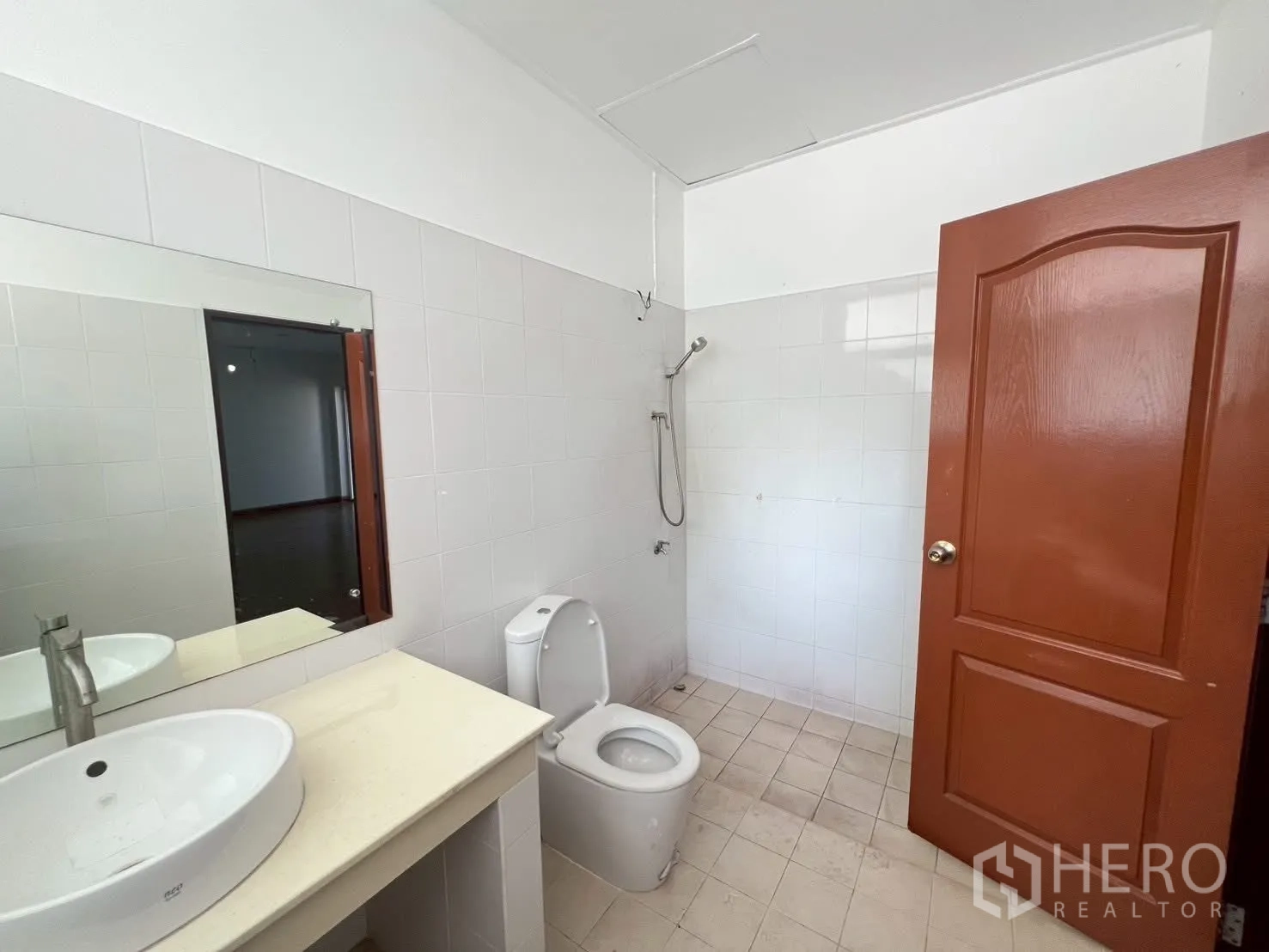 Detached House for rent in Watthana, Bangkok - Tiled bathroom with vanity sink, toilet, and a walk-in shower area.