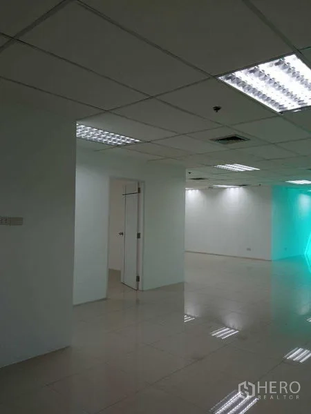 Office Space for rent in Huai Khwang, Bangkok - Office corner with white walls, grid ceiling and fluorescent lights, plus an internal doorway.