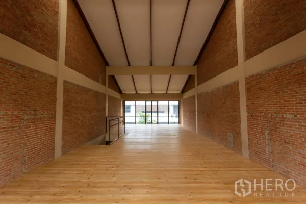 Home Office for rent in Watthana, Bangkok - Long rectangular hall with exposed brick walls and large front glazing.