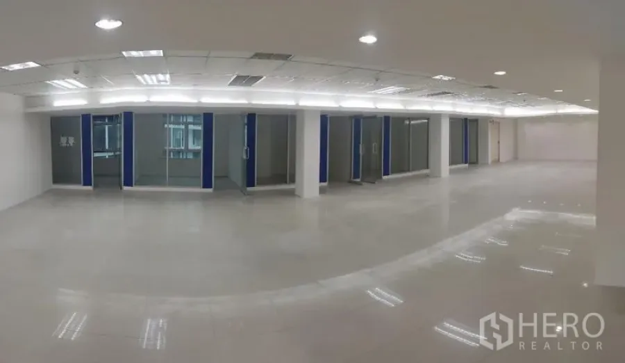 Office Space for rent in Chatuchak, Bangkok - Spacious open-plan office with glossy tile flooring, grid ceiling lights, central air and glass-partitioned rooms along one side.