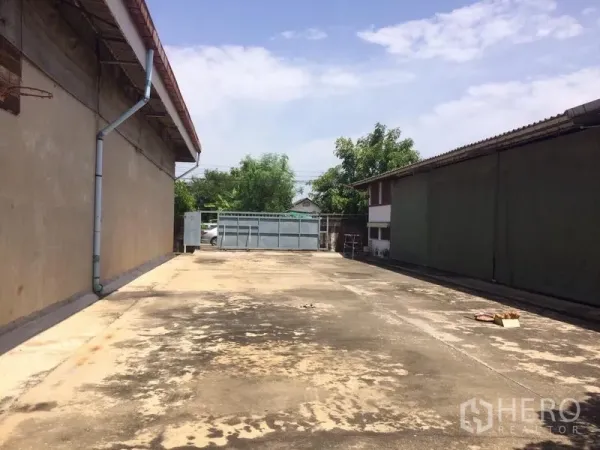 คลังสินค้า ให้เช่าในSamut Prakan - ลานคอนกรีตกว้างระหว่างอาคารโกดัง มองไปยังประตูรั้ว