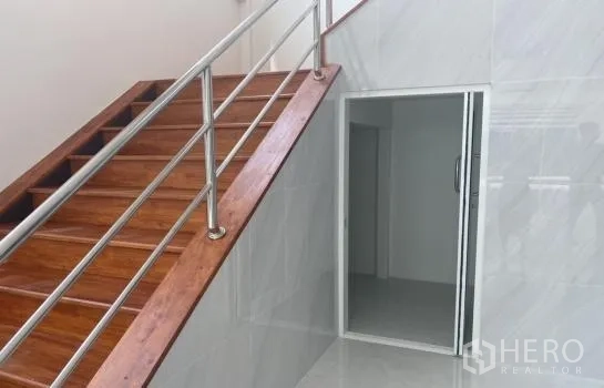 货栈 出租在Prawet, Bangkok - 木质楼梯配不锈钢扶手，通往楼上办公室，旁有推拉门入口。