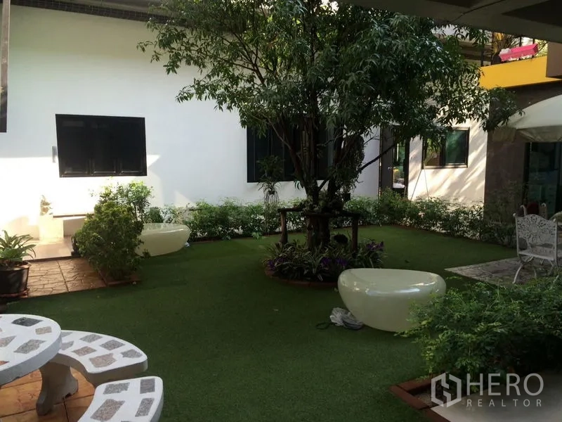 สำนักงานที่บ้าน ขาย - ลานสวนจัดแต่งมีต้นไม้ใหญ่ สนามหญ้า และที่นั่งภายในโครงการ