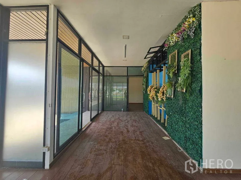 带办公室的家 出租在Prawet, Bangkok - 大厅走廊，整面玻璃与垂直绿植墙。