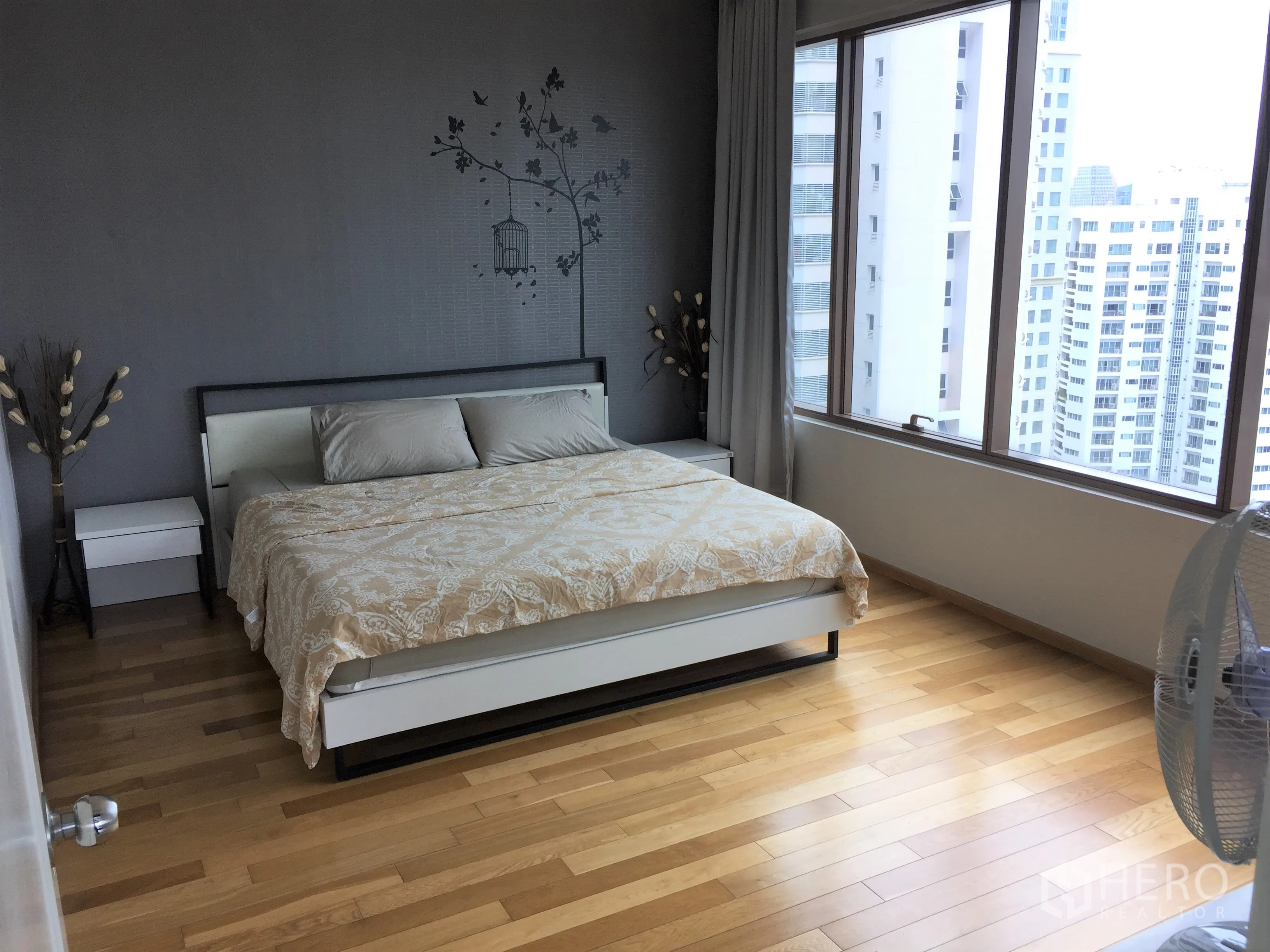Condominium for rent or sale in Khlong Toei, Bangkok - Second bedroom with king bed, wood flooring and wide city-view windows.