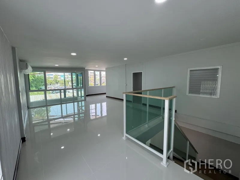 Townhouse for sale in Bueng Kum, Bangkok - Spacious upper floor lounge with white tile floors and large windows.