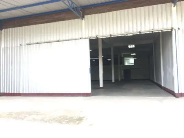 货栈 出租在Bueng Kum, Bangkok - 仓库正面，大型金属滑门与带顶装卸区。