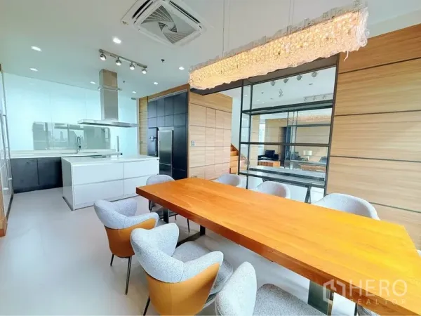 คอนโด ให้เช่าหรือขายในKhlong Toei, Bangkok - โซนกินข้าวสว่าง โต๊ะไม้ยาว เก้าอี้ผ้า ฉากกั้นกระจก และครัวไอแลนด์สีขาวพร้อมฮูด