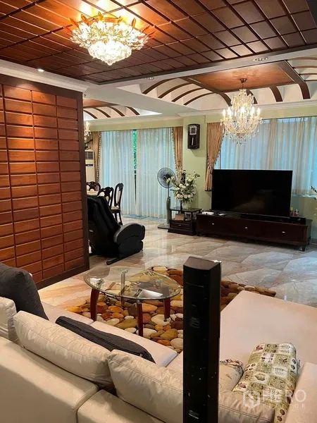 Detached House for sale in Bueng Kum, Bangkok - Spacious living room with chandeliers, TV console, and wood coffered ceiling.