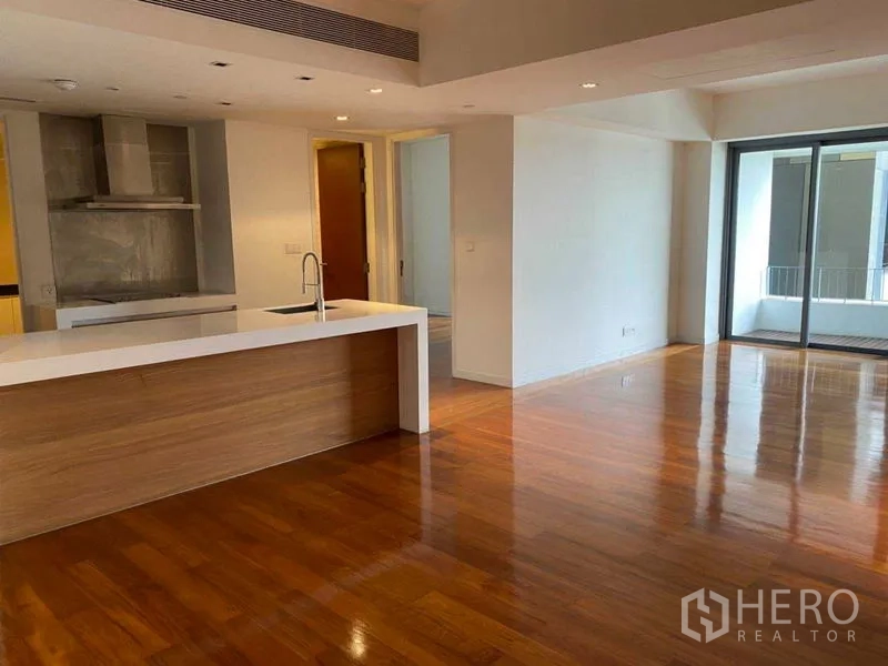 Condominium for rent in Yan Nawa, Bangkok - Spacious open-plan living and dining with a kitchen island and floor-to-ceiling doors to the balcony.