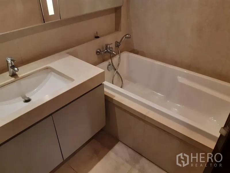 คอนโด ให้เช่าในWatthana, Bangkok - อีกมุมของห้องน้ำที่มีอ่างอาบน้ำแบบฝังพร้อมฝักบัวมือถือ และเคาน์เตอร์ซิงก์ดีไซน์ทันสมัย