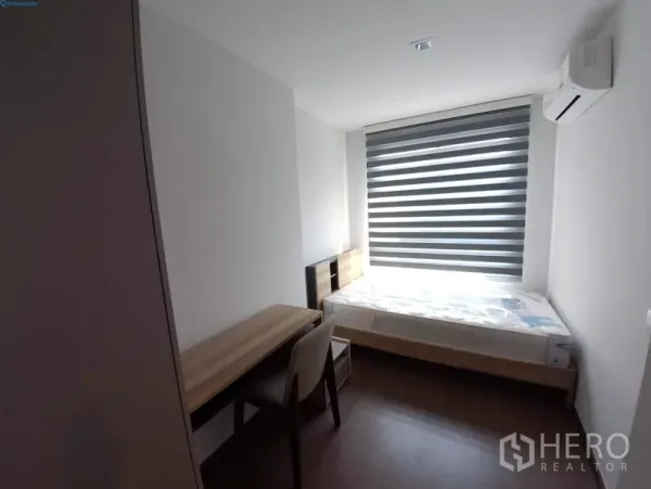 公寓 出租在Phra Khanong, Bangkok - 次卧配单人床、书桌、空调和百叶帘。