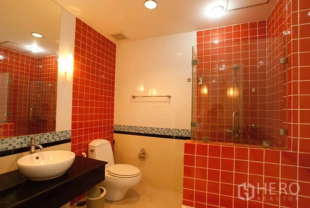 公寓 出租在Khlong Toei, Bangkok - 现代浴室，红色马赛克墙面，玻璃淋浴间与台盆马桶。