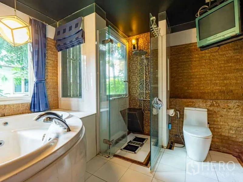 Detached House for sale in Suan Luang, Bangkok - Bathroom with jacuzzi bathtub, glass shower enclosure and a window.