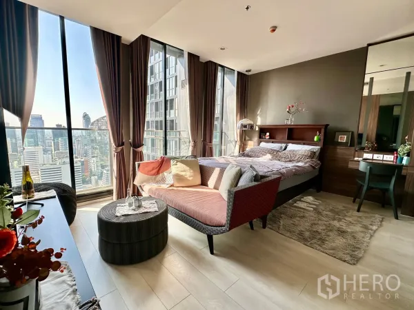 Condominium for rent in Pathum Wan, Bangkok - Sunlit studio-style bedroom with seating area and skyline outlook.