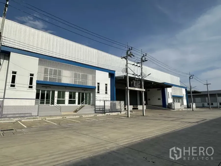 工厂 出租在Bang Sao Thong, Samut Prakan - Bang Sao Thong现代厂房外观，宽阔混凝土前场与停车位、带顶装卸区
