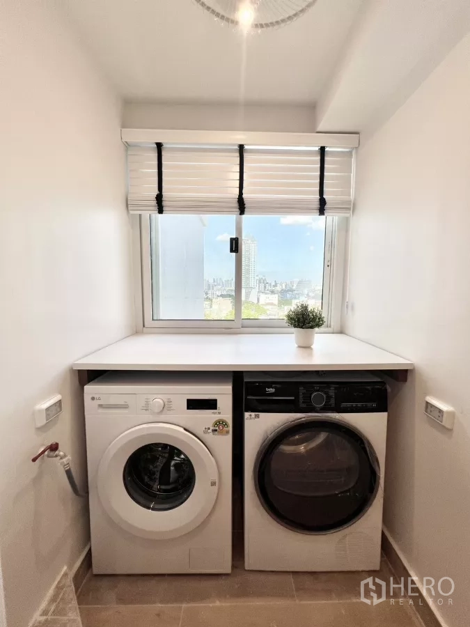 公寓 出售在Yan Nawa, Bangkok - 靠窗并排的洗衣机与烘干机，可见城市景观。