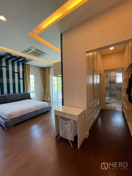 独立式住宅 出租在Bang Phli, Samut Prakan - 主卧套房，步入式衣帽间与卫浴，木地板与灯带