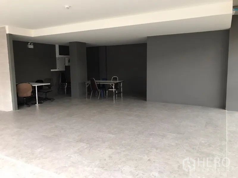 零售空间 出租在Khlong Toei, Bangkok - 开敞式零售空间，灰色瓷砖地面与深色墙面。