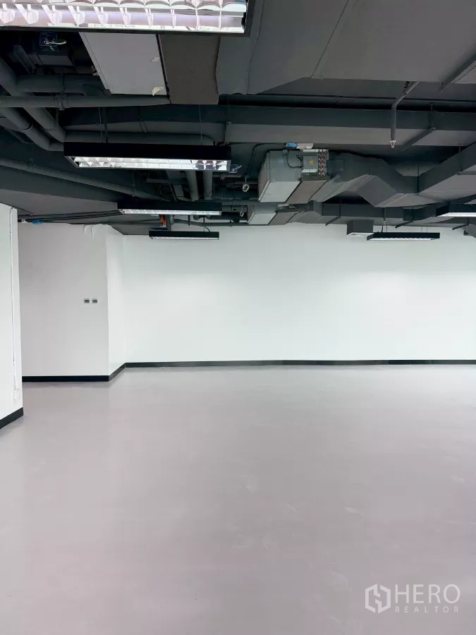 办公空间 出租在Din Daeng, Bangkok - 白色墙面办公区，外露黑色天花与集中空调管道及LED灯。