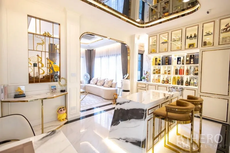 Detached House for sale in Pak Kret, Nonthaburi - Open‑plan bar and pantry with marble island, backlit display cabinet and lounge connection.