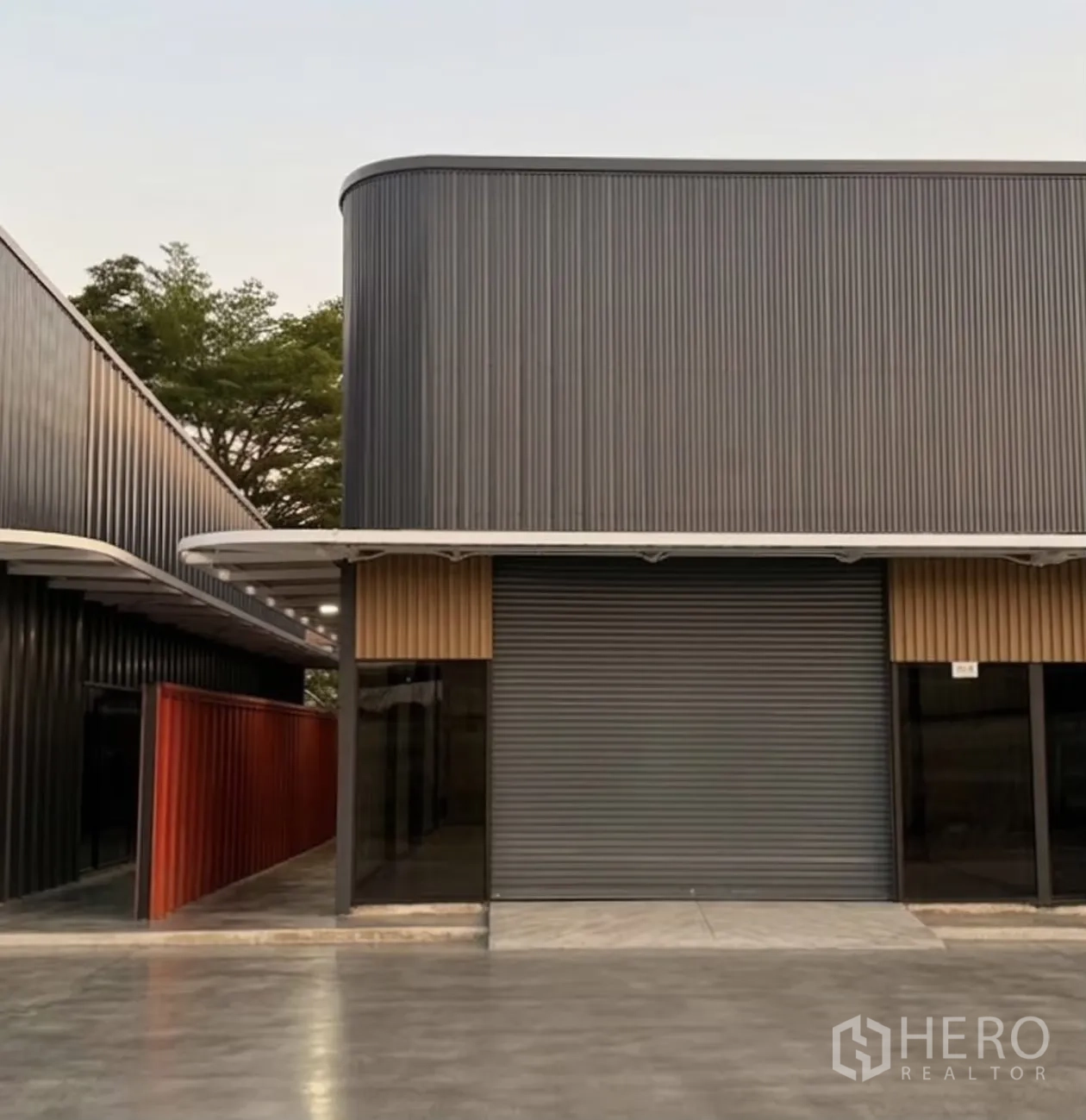Warehouse for rent in Suan Luang, Bangkok - Modern warehouse exterior with corrugated cladding, large roll-up door, and a covered walkway.