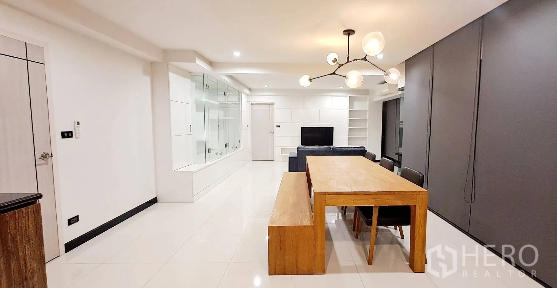 Apartment for rent in Phra Khanong, Bangkok - Spacious living area with blackout blinds and an air-conditioning unit.