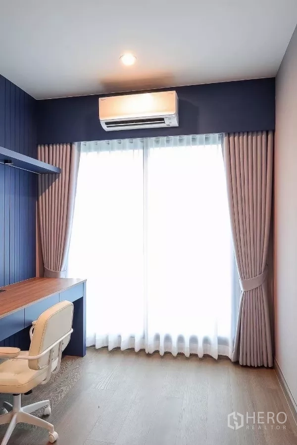 บ้าน ให้เช่าหรือขายในPrawet, Bangkok - ห้องทำงานกะทัดรัด โต๊ะบิลท์อิน เก้าอี้ล้อเลื่อน ผนังสีน้ำเงิน และประตูกระจกพร้อมผ้าม่าน