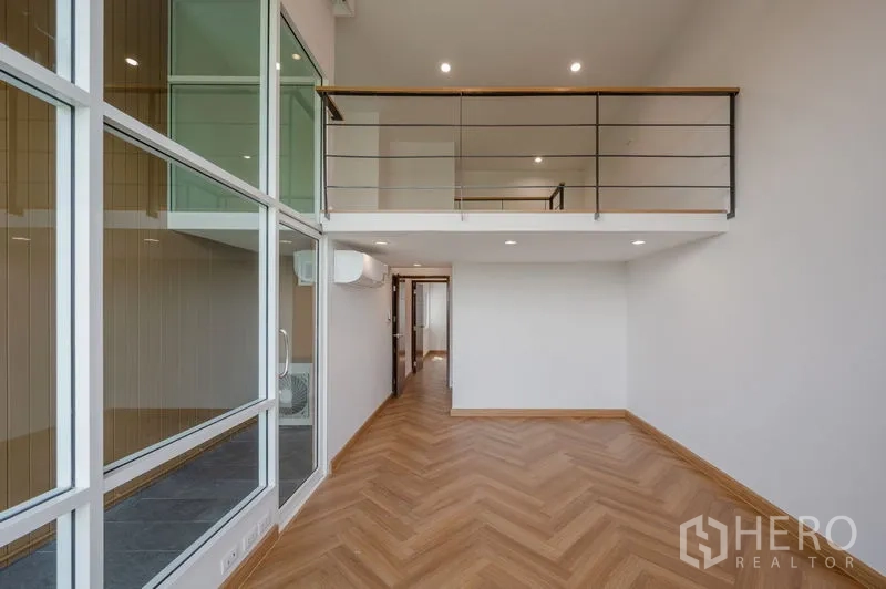 ทาวน์เฮาส์ ขายในLat Phrao, Bangkok - ห้องเพดานสูงมองไปยังชั้นลอยและผนังกระจกกว้าง