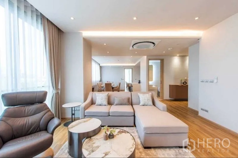 Detached House for rent or sale in Khan Na Yao, Bangkok - Bright open-plan living and dining room with sectional sofa and armchair.