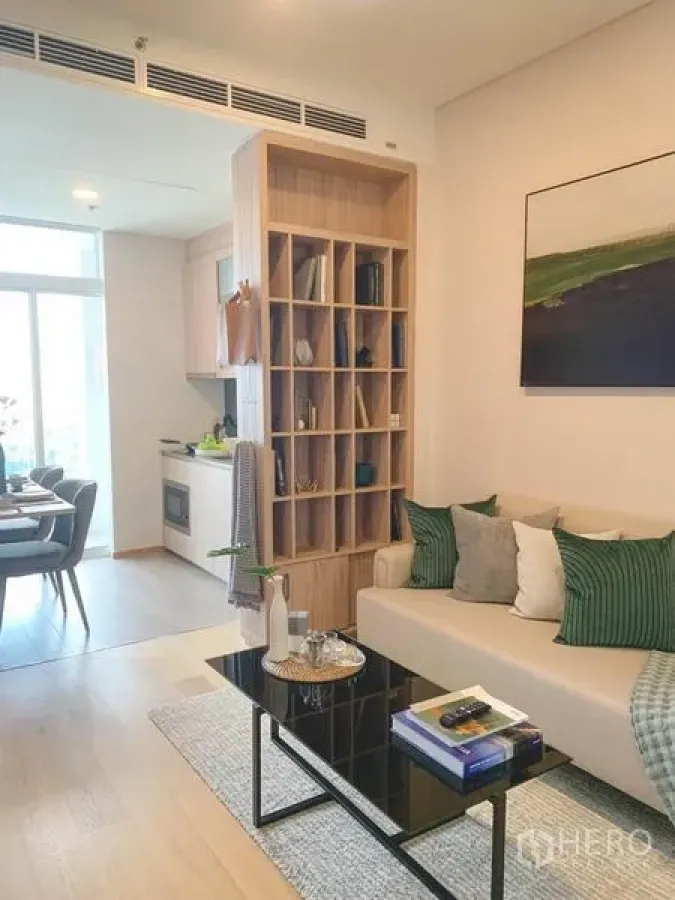 คอนโด ขายในKhlong Toei, Bangkok - ห้องนั่งเล่นสว่าง โซฟาสีเบจ โต๊ะกระจก และชั้นไม้กั้นพื้นที่ เชื่อมครัวและมุมทานอาหาร