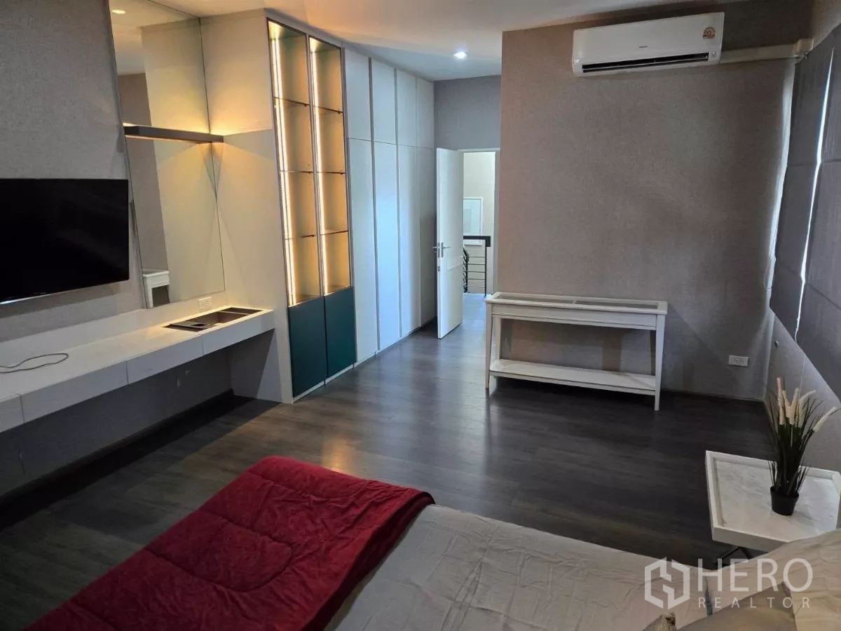 Detached House for rent or sale in Bang Phli, Samut Prakan - Additional bedroom with minimalist decor, bedside shelf, and wood floors.