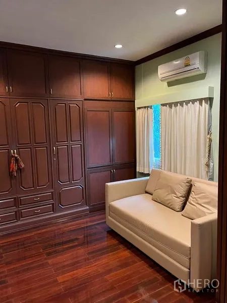 Detached House for sale in Bueng Kum, Bangkok - Bedroom or study with built-in wooden wardrobes and a compact sofa.