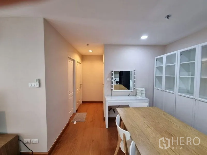 公寓 出租在Huai Khwang, Bangkok - 明亮的用餐区，带化妆台、玻璃展示柜和温暖木地板。