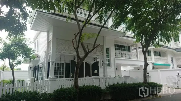 独立式住宅 出租在Mueang Samut Prakan, Samut Prakan - 三层白色独栋住宅，白色栅栏与阳台栏杆，临街绿树成荫的安静小巷。