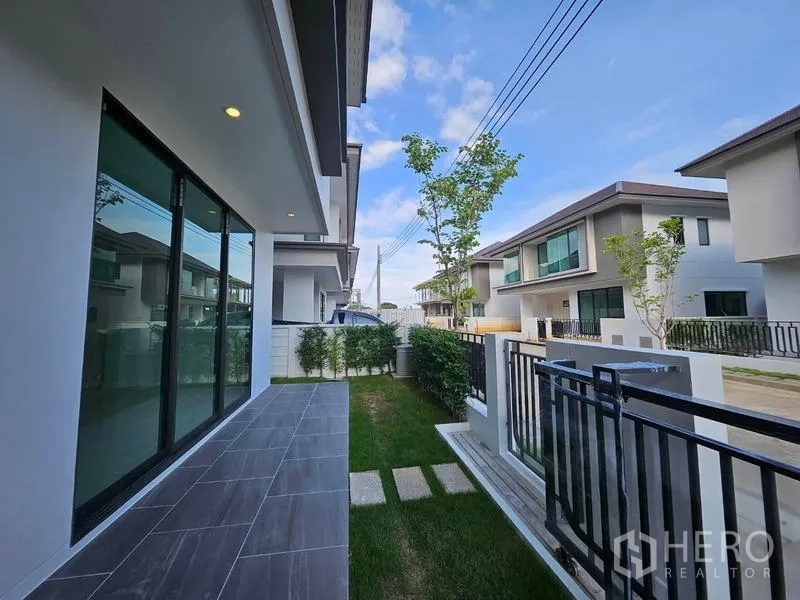 บ้าน ให้เช่าในSaphan Sung, Bangkok - เฉลียงข้างบ้านเชื่อมประตูกระจกบานเลื่อนไปยังสวนหญ้าและรั้ว