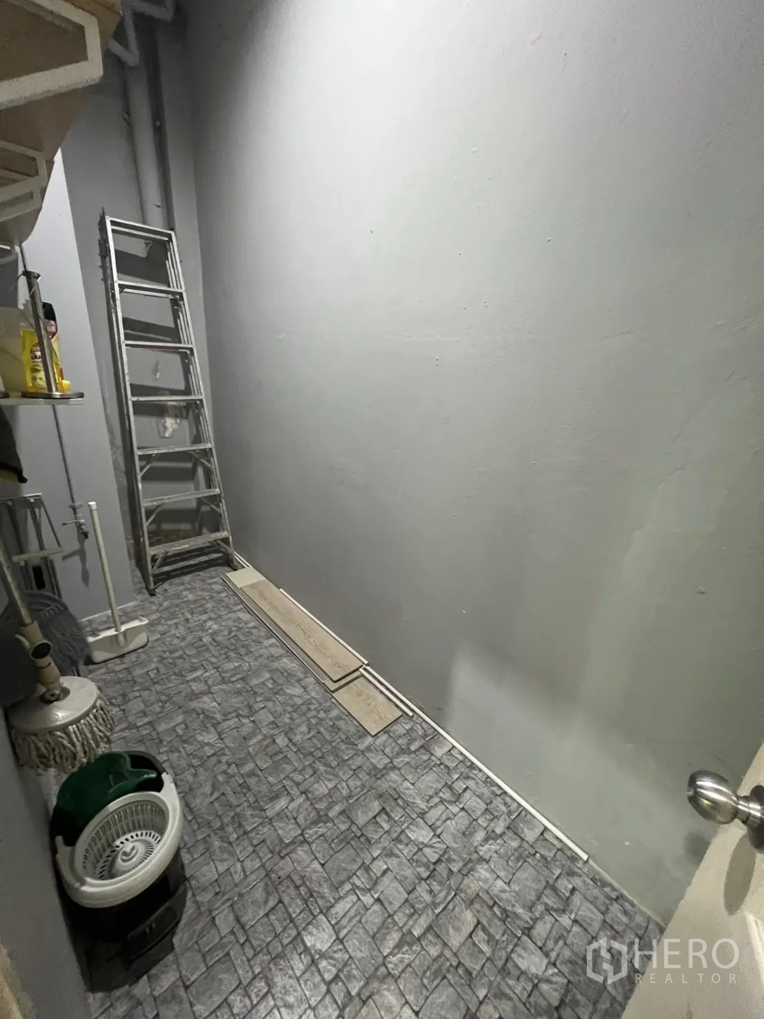 零售空间 出租在Watthana, Bangkok - 后勤储物间，仿石地面、置物架与梯子。