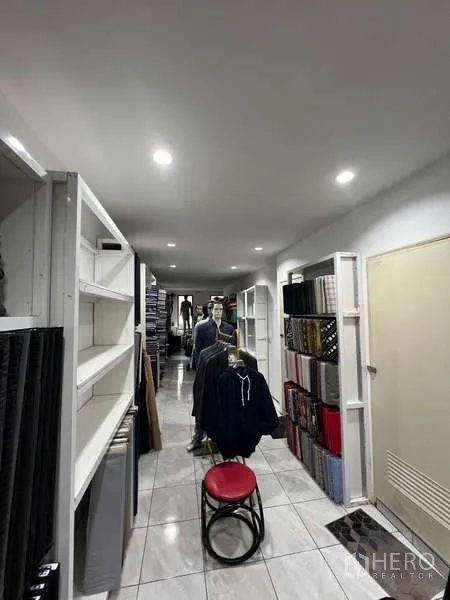 零售空间 出租在Khlong Toei, Bangkok - 狭长型商铺走道，内置货架、瓷砖地面与嵌入式灯光。