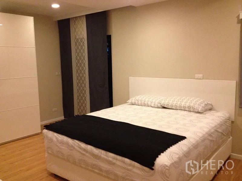 公寓 出租在Pathum Wan, Bangkok - 明亮卧室，白色床架、衣柜与中性色墙面。