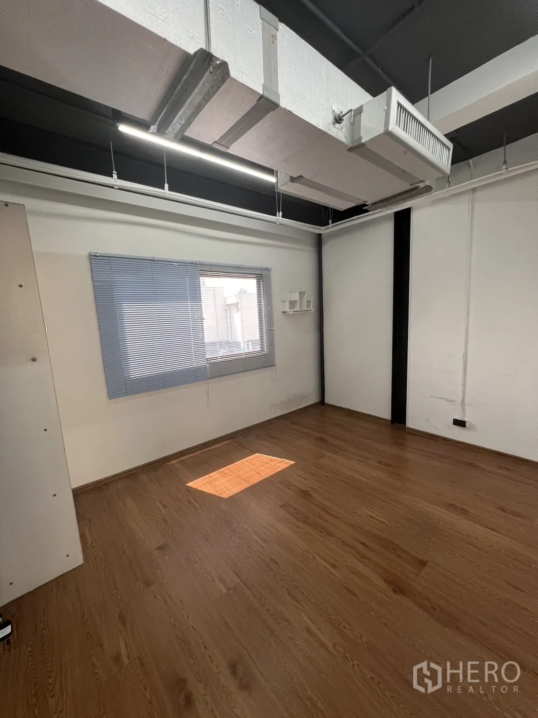 Office Space for rent in Khlong Toei, Bangkok - Private office room with window blinds, suspended AC ducting and warm wood flooring.