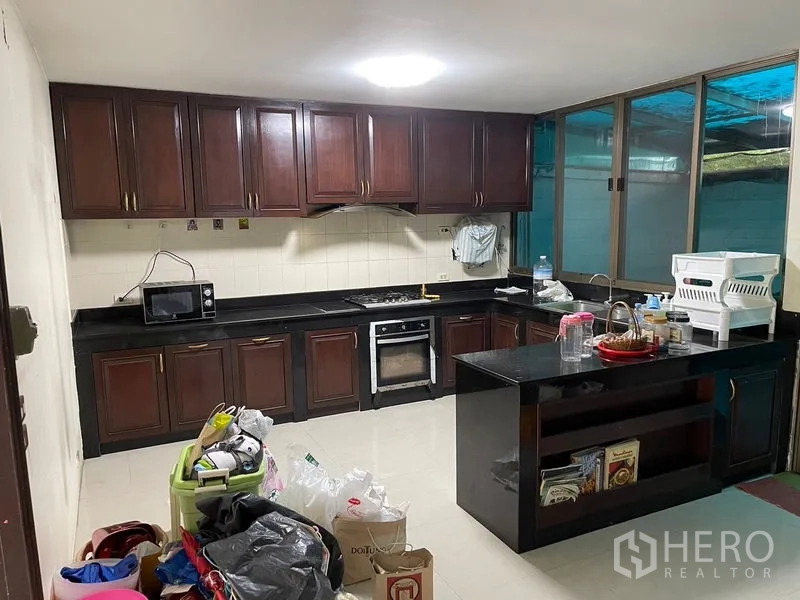 สำนักงานที่บ้าน ให้เช่าในWatthana, Bangkok - ครัวครบชุด เตาแก๊ส เตาอบ เคาน์เตอร์สีดำ และตู้แขวน