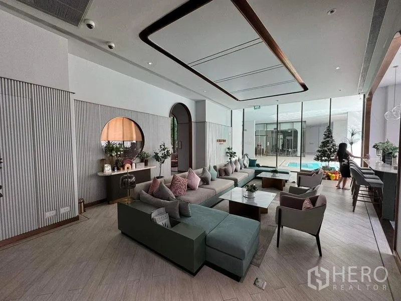 Condominium for rent in Watthana, Bangkok - Stylish residents’ lounge with ample seating and pool view inside the condominium clubhouse.