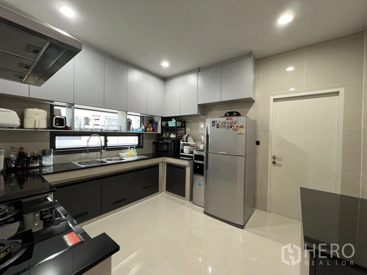 Detached House for rent or sale in Bang Kapi, Bangkok - U-shaped modern kitchen with grey cabinetry, double sink and large fridge.