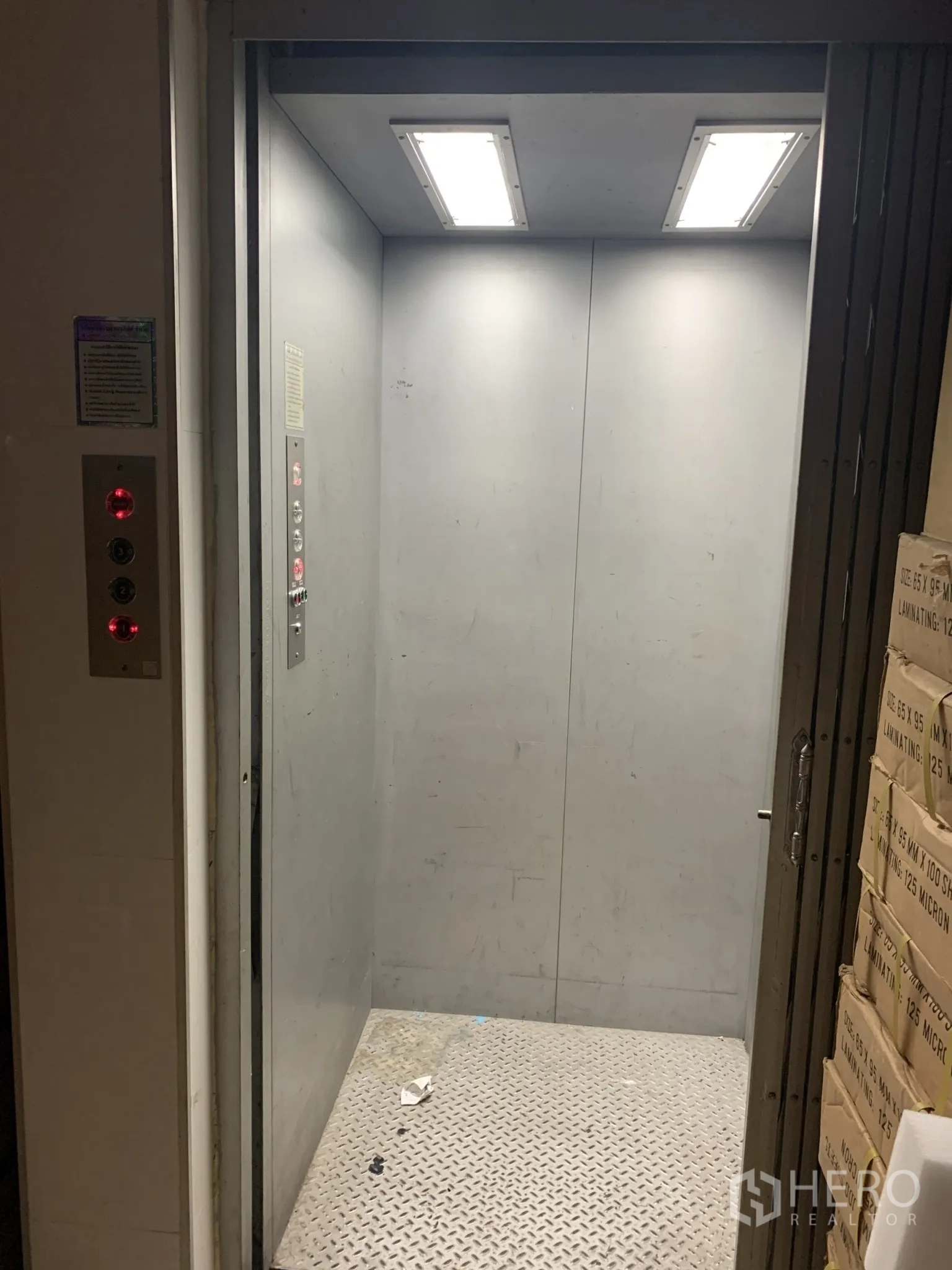 店屋 出售在Pathum Wan, Bangkok - 货运电梯内景，金属墙面、明亮顶灯与防滑金属地板。